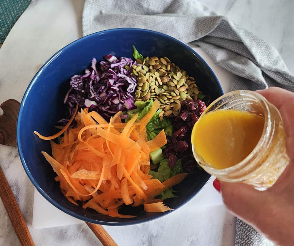 a picture of dressing pouring into a bowl