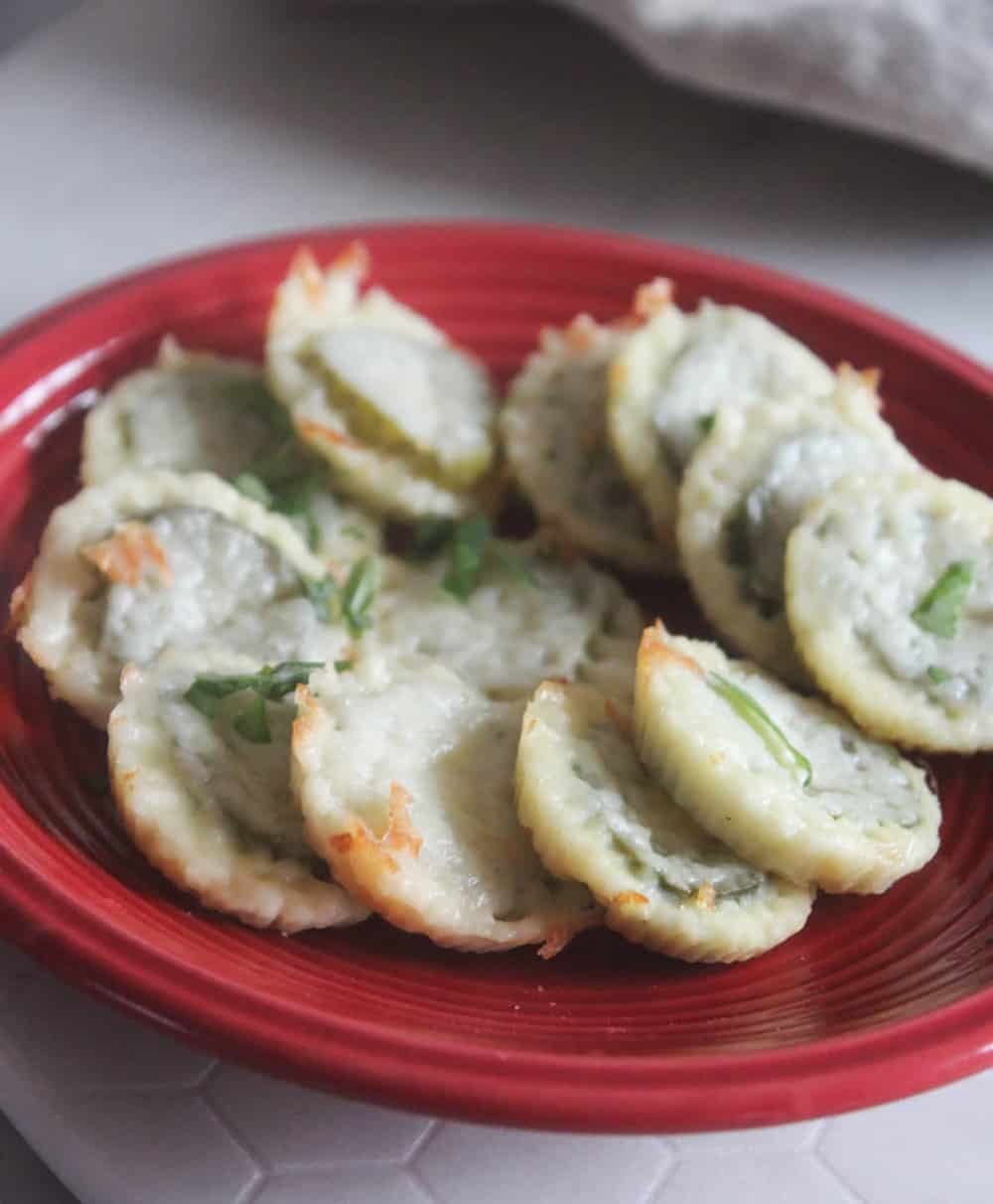 A pictue of cheese bites with pickles on a plate