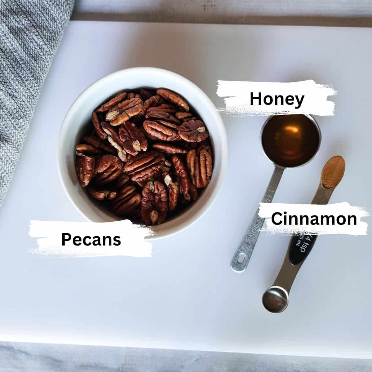 A picture of three ingredients needed for honey cinnamon pecans: Pecans, Honey, Cinnamon