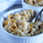 a close up picture of mac n cheese in a bowl with a fork