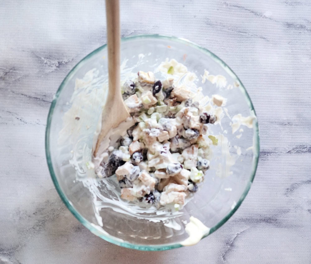 Cape cod chicken salad process step 2, all ingredients mixed together in a glass bowl