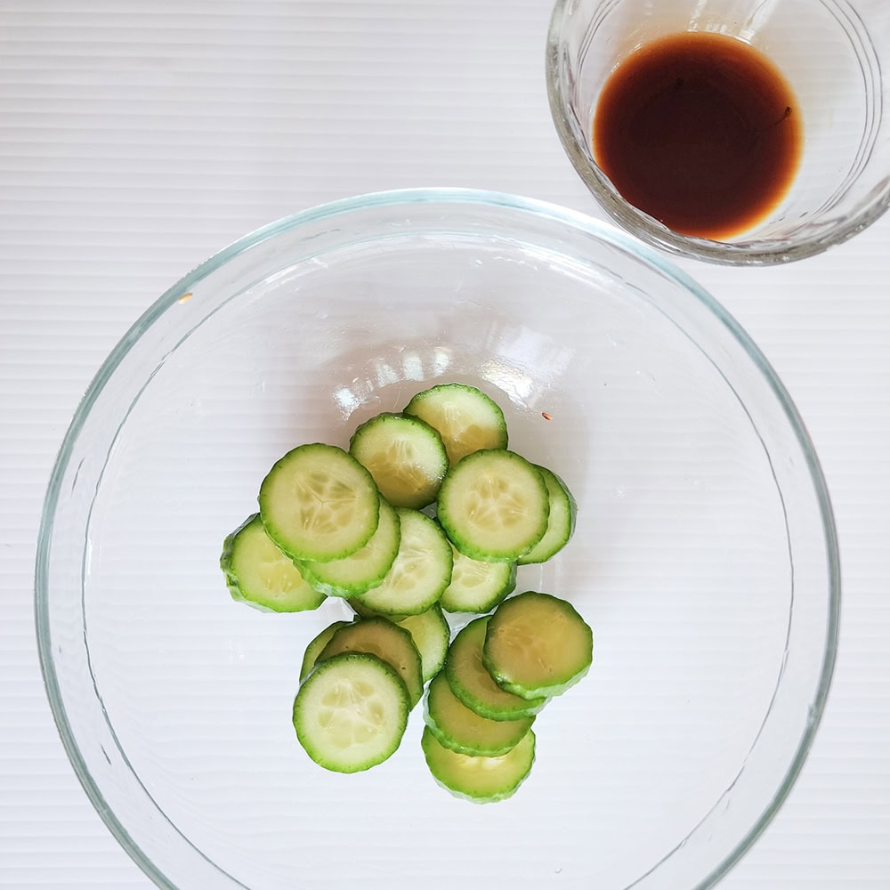 sliced cucumbers in a glass bowl with salt