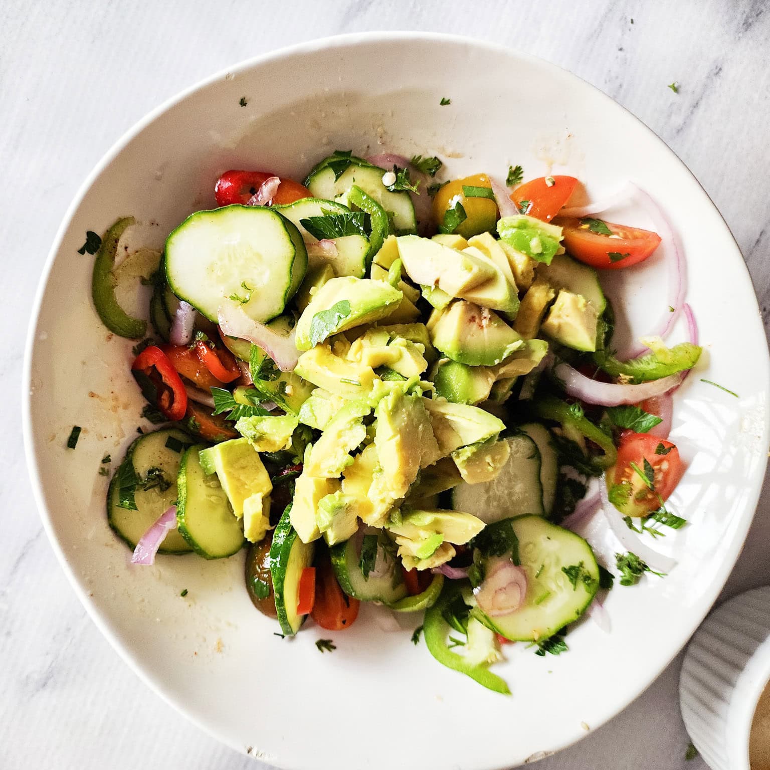 avocado salad process step 2 ingredients in bowl with avocado on top