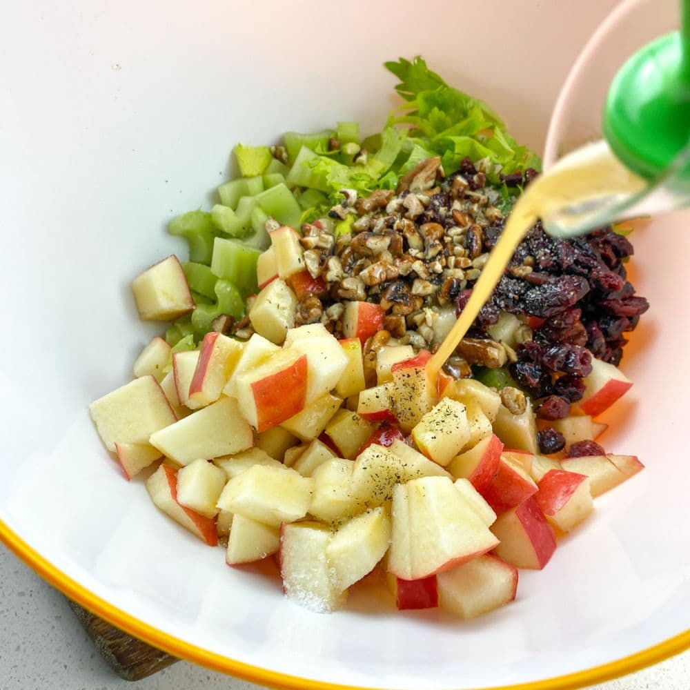 a picture of the salad ingredients with the dressing pouring in