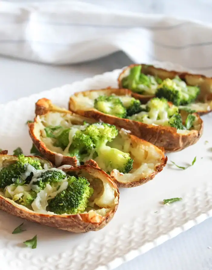 4 cheesy broccoli filled air fryer potato skins on a white plate